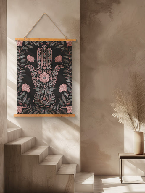 Botanical Hamsa wall tapestry featuring intricate rose gold and teal design on black background, showing a protective hand symbol surrounded by leaf motifs and floral elements, hanging from wooden dowels with natural twine.